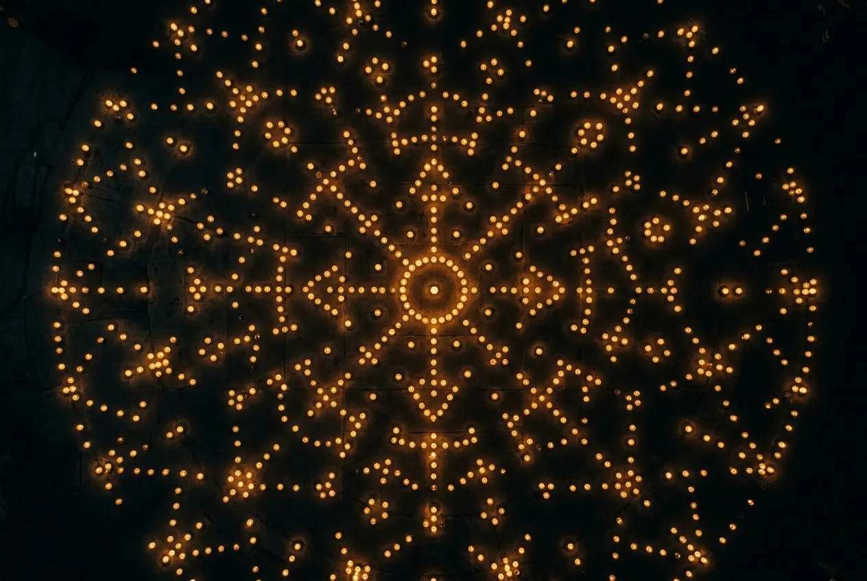俯瞰視角，數百點燭火散落黑暗大地，集體光點隱約構成星座曼陀羅圖形，象徵個體覺醒匯聚成集體轉化